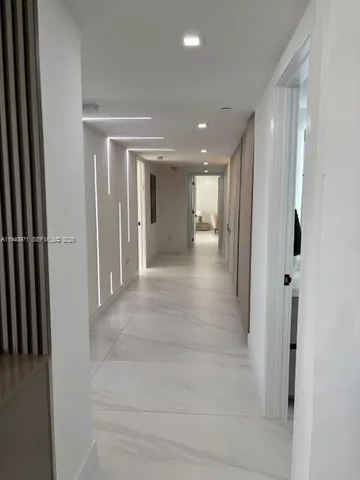 a bedroom with a bed a flat screen tv and a large window