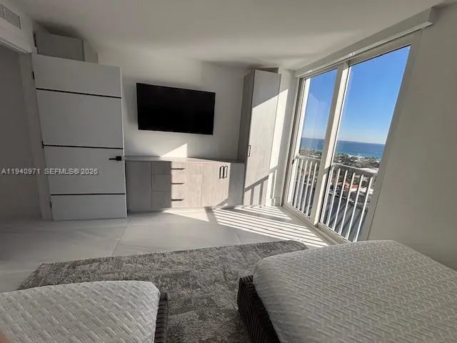 a dining room with furniture and a floor to ceiling window