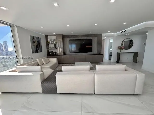 a bedroom with a bed a couch and a flat screen tv