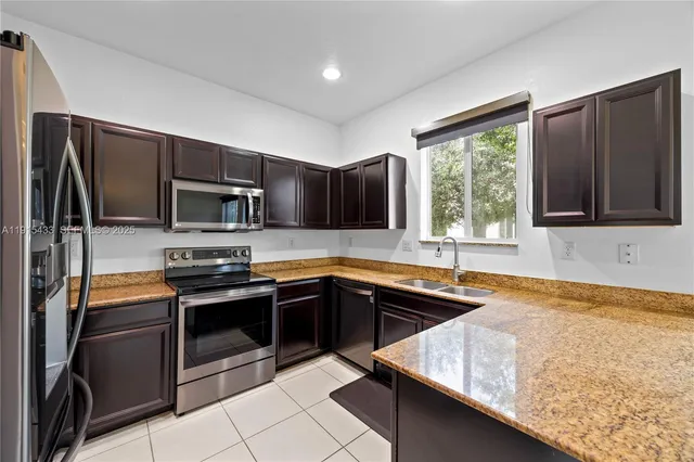 a kitchen with stainless steel appliances granite countertop a sink stove and microwave