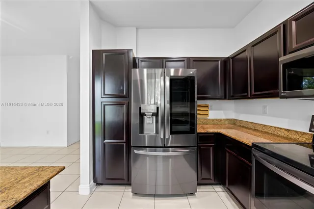 a kitchen with stainless steel appliances granite countertop a refrigerator and a stove