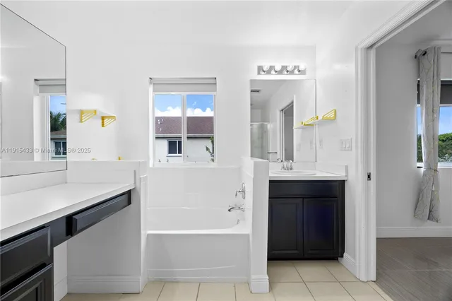 a bathroom with a bathtub sink and mirror