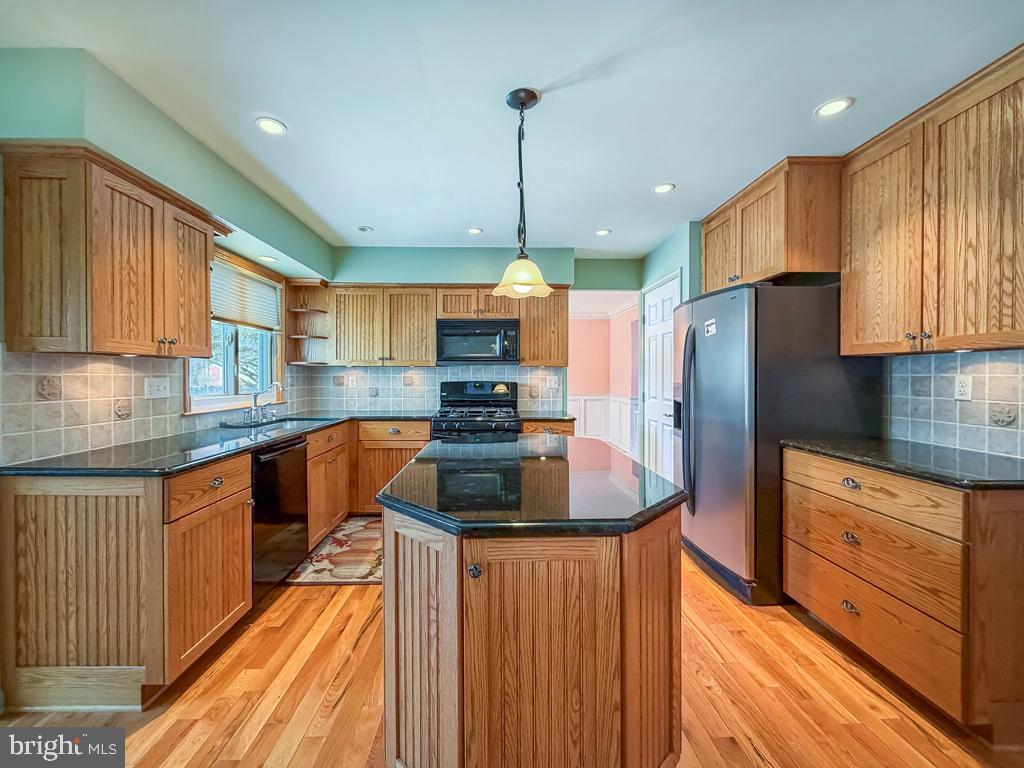 304 Barnsbury Road Langhorne, PA 19047 - Photo 11 of 55 a kitchen with stainless steel appliances granite countertop a refrigerator a sink dishwasher a stove and white countertops with wooden floor