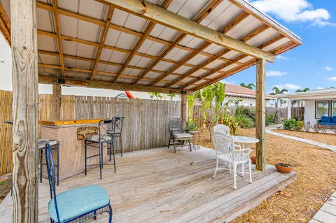 a view of a patio with table and chairs with wooden floor and fence
