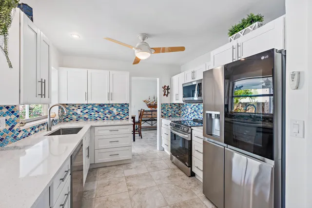 a kitchen with granite countertop a refrigerator stove and oven