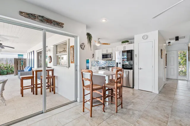 a dining room with stainless steel appliances kitchen island granite countertop a table and chairs