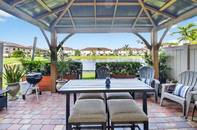 a patio with glass top table and chairs