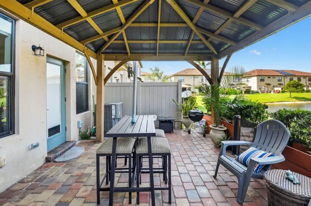 a patio with glass top table and chairs