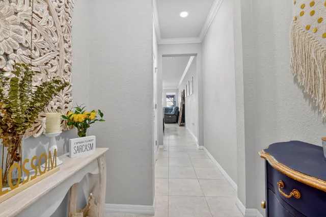 a hallway with painting and a potted plant