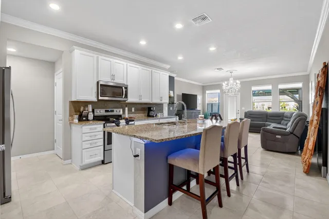 a kitchen with kitchen island granite countertop wooden cabinets and stainless steel appliances