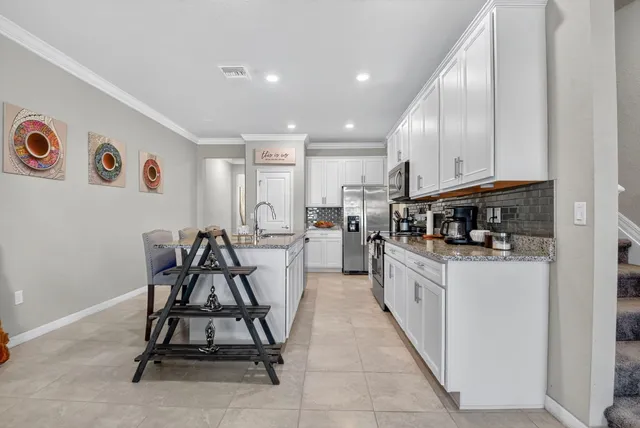 a kitchen with granite countertop a table and chairs in it