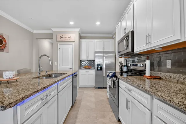 a kitchen with stainless steel appliances granite countertop a sink stove and refrigerator