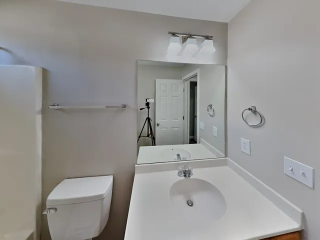 a bathroom with a sink a toilet and mirror
