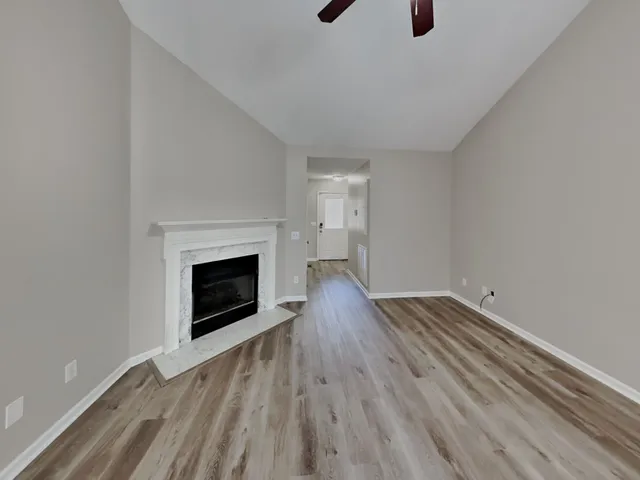 a view of empty room with wooden floor and fireplace