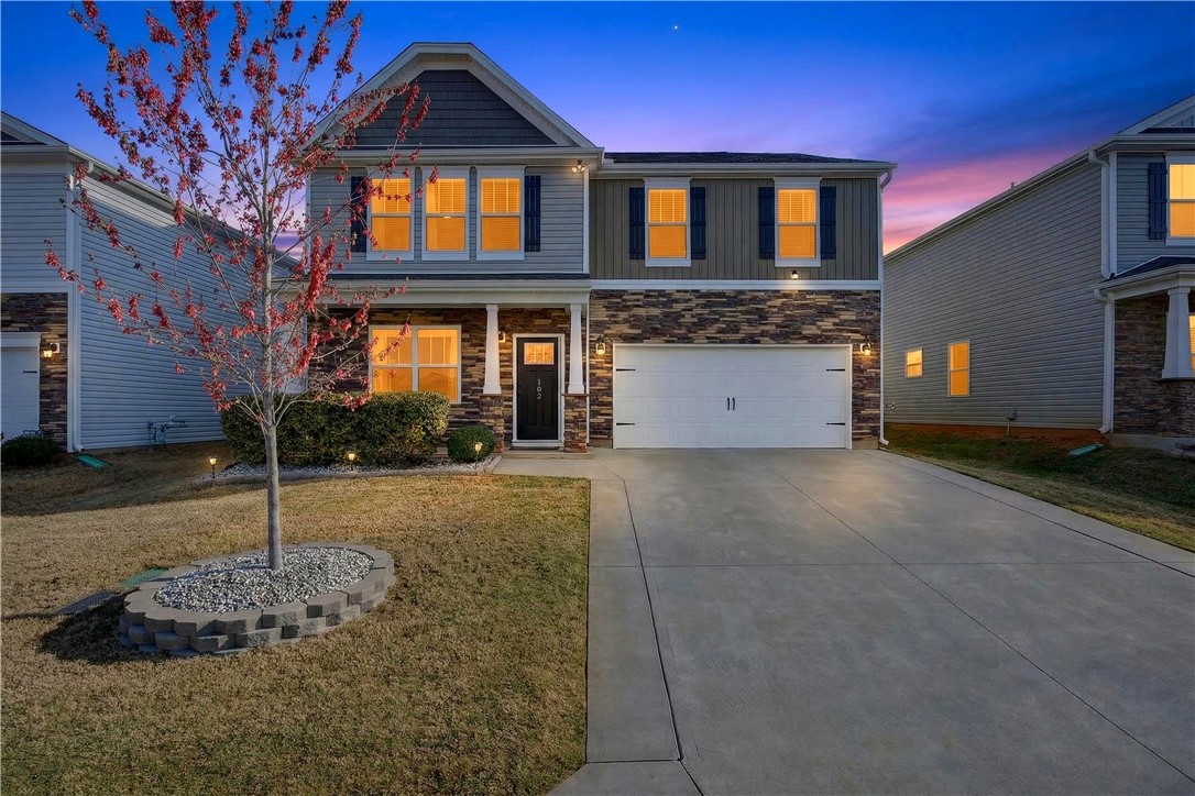 This charming home features a well-manicured lawn and a spacious driveway, perfect for evening arrivals.