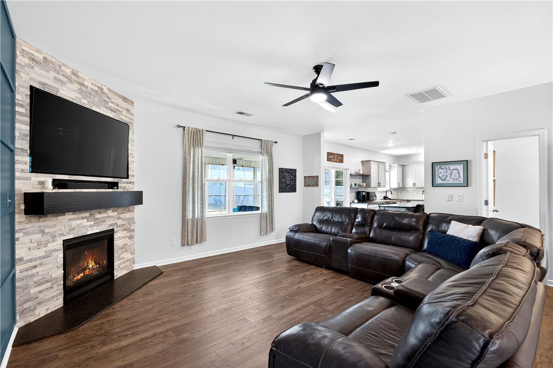 102 Preservation Drive Greer, SC 29650 - Photo 18 of 44 This living room features a fireplace and wood flooring, perfect for cozy gatherings.