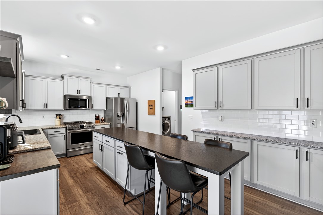 102 Preservation Drive Greer, SC 29650 - Photo 21 of 44 This modern kitchen features a spacious island and sleek stainless steel appliances.