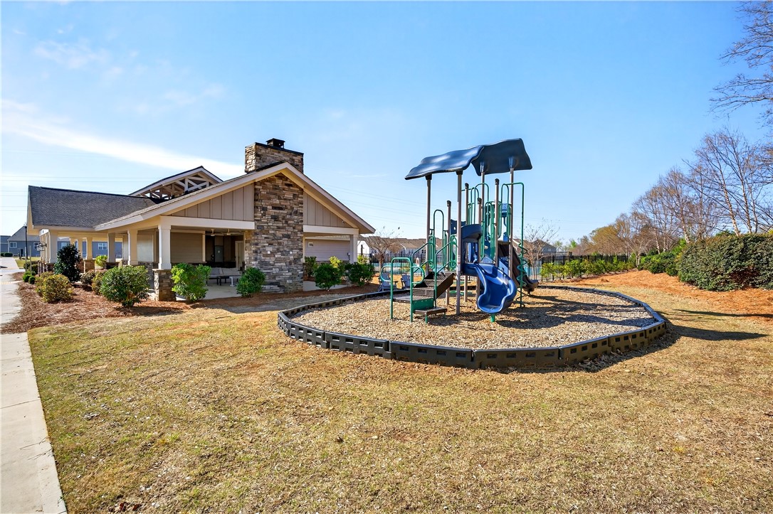 102 Preservation Drive Greer, SC 29650 - Photo 41 of 44 This community amenity features a charming clubhouse and an engaging playground, perfect for leisure.