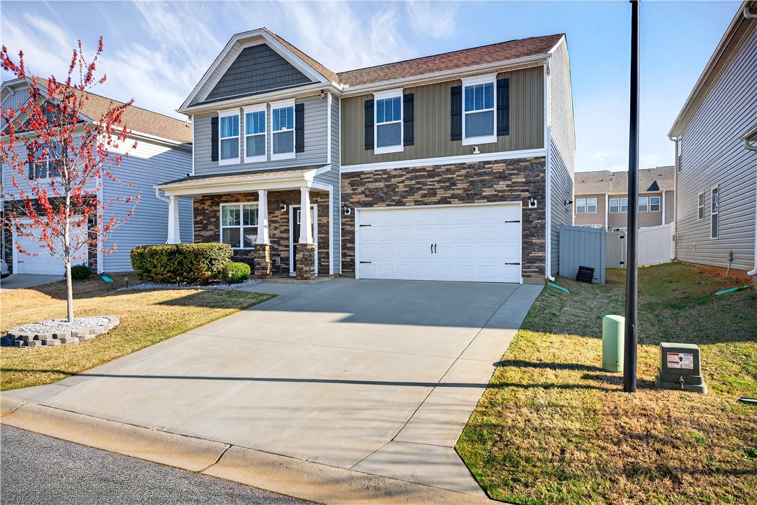 102 Preservation Drive Greer, SC 29650 - Photo 9 of 44 This two-story residence features a welcoming facade with a mix of siding and stone accents.