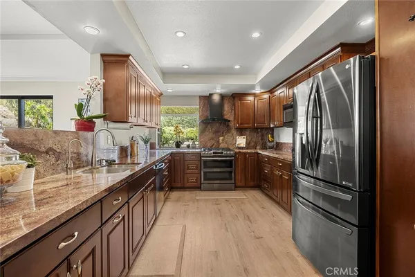 a kitchen with stainless steel appliances granite countertop a refrigerator and a sink