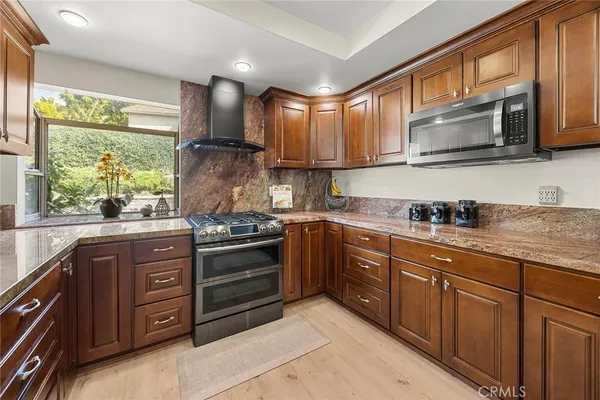 a kitchen with stainless steel appliances granite countertop a stove sink and microwave