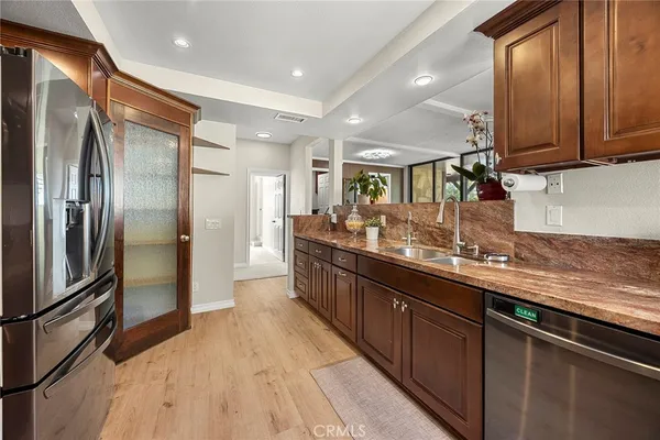 a kitchen with stainless steel appliances granite countertop a refrigerator a sink and a stove