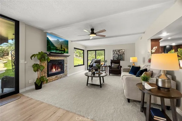 a living room with furniture a fireplace and a flat screen tv