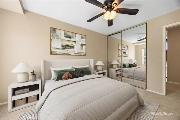 a bedroom with a bed painting on wall and a large window