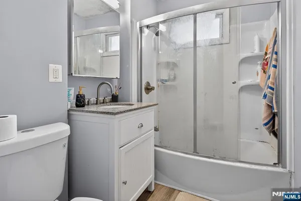 a bathroom with a granite countertop sink a toilet and shower