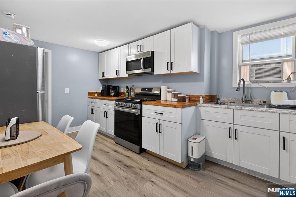 229 Patterson Street Harrison, NJ 07029 - Photo 15 of 25 a kitchen with stainless steel appliances granite countertop a stove a sink dishwasher and a refrigerator