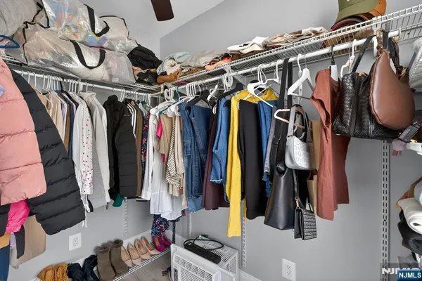a view of walk in closet with clothes and shoes