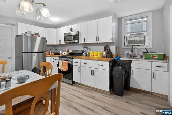 a kitchen with a sink a refrigerator a stove a dining table and chairs