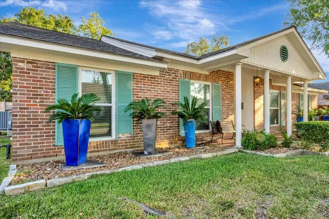 a front view of a house with a garden and plants