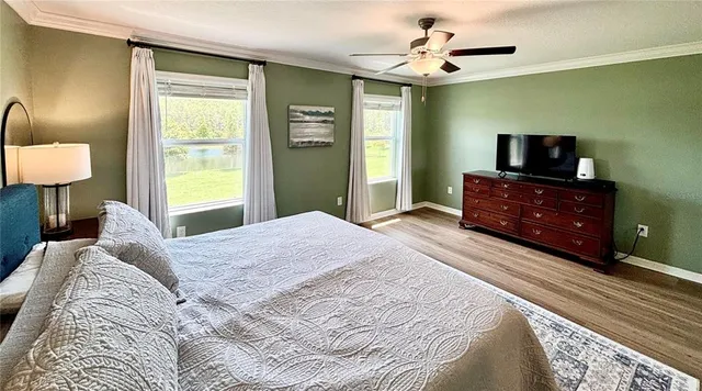 a bedroom with a bed and a flat tv screen on dresser