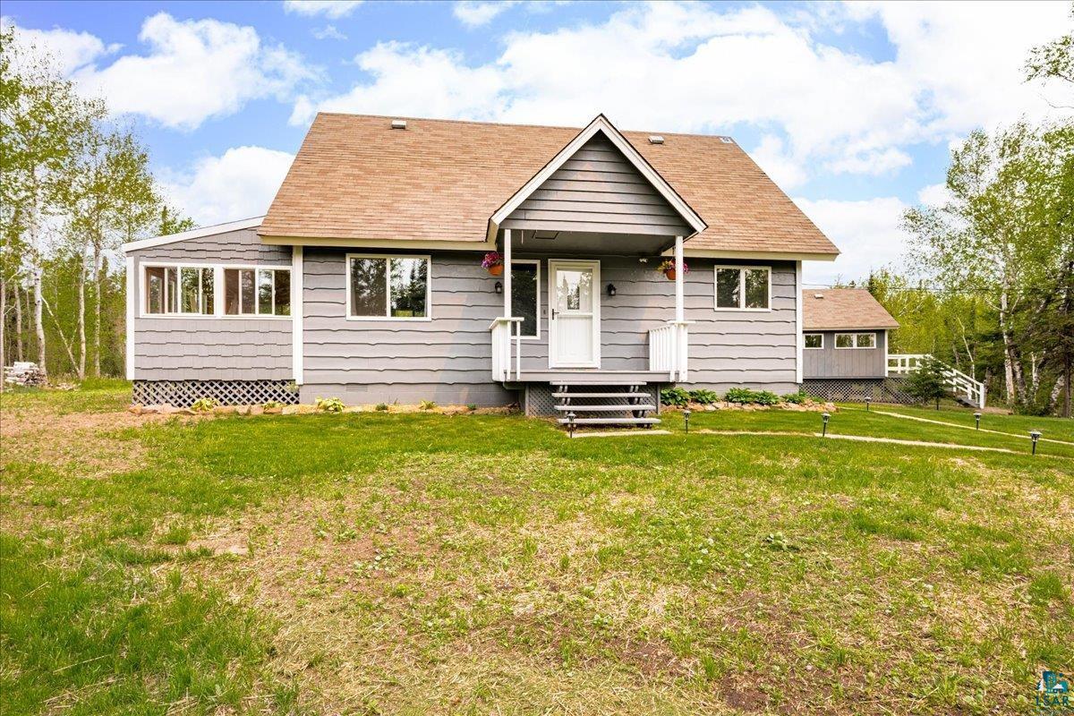 5923 North Shore Drive Duluth, MN 55804 - Photo 26 of 38 View of front of house featuring a front yard, roof with shingles, and a porch