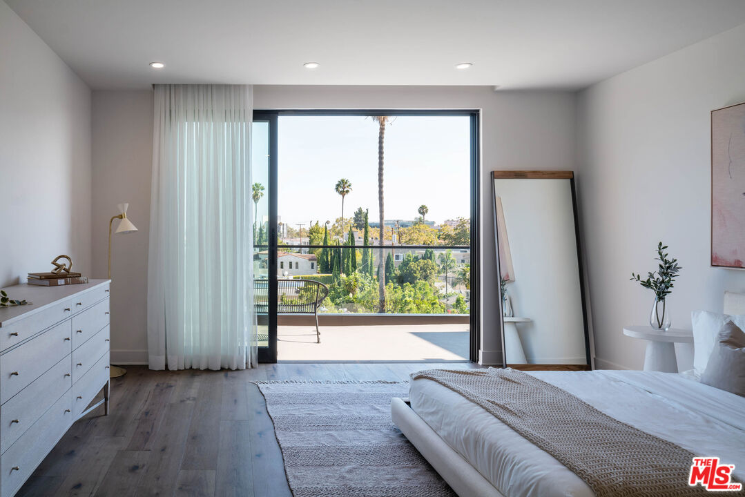 411 South Hamel Road, Unit 401 Los Angeles, CA 90048 - Photo 16 of 19 a view of a bedroom with a large bed and wooden floor