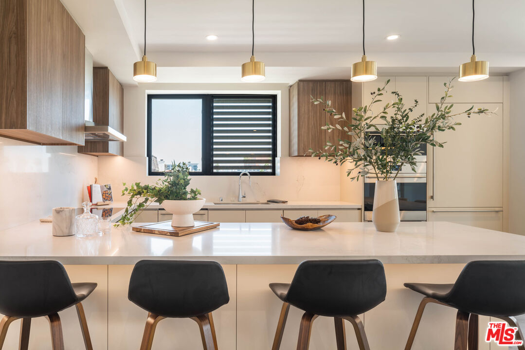 411 South Hamel Road, Unit 401 Los Angeles, CA 90048 - Photo 4 of 19 a kitchen with a table chairs stove and cabinets