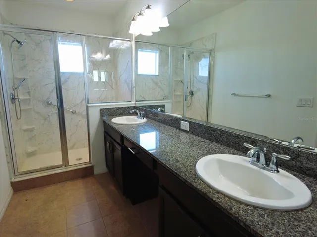 a bathroom with a granite countertop sink and a mirror