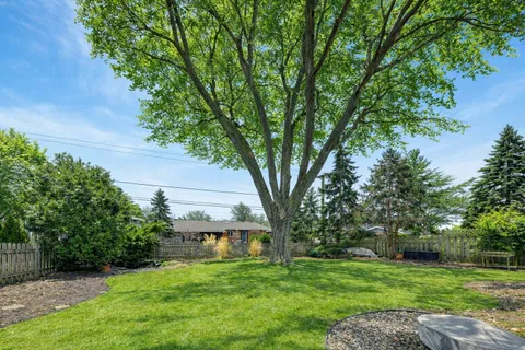a view of a house with a big yard and large trees