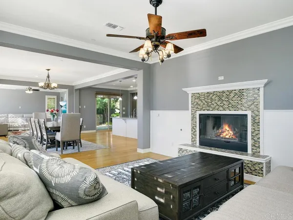 a living room with furniture a fireplace and a chandelier