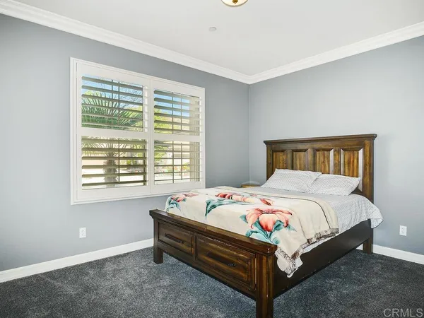 a bed sitting in a bedroom next to a window
