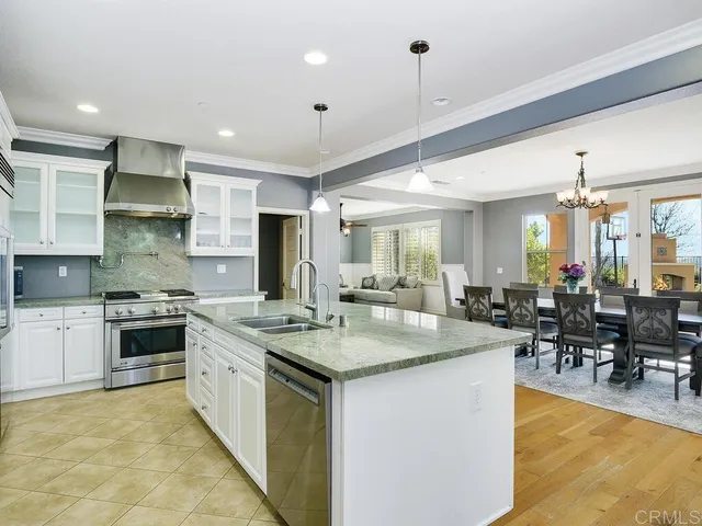 a large kitchen with kitchen island a sink table and chairs