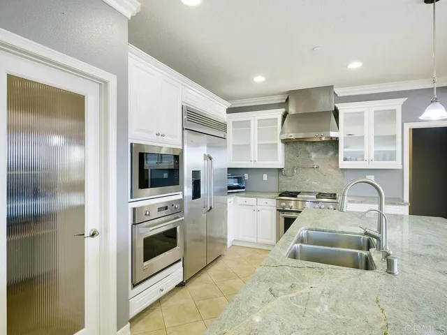 a kitchen with stainless steel appliances a stove a sink and a refrigerator