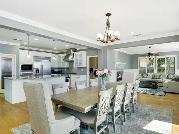 a dining room with furniture a chandelier and wooden floor