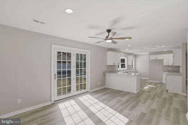 a view of an empty room with a window and a ceiling fan