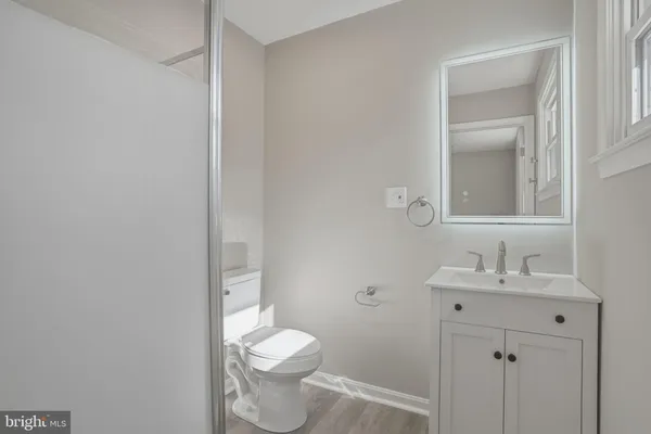 a bathroom with a bathtub shower sink vanity and toilet