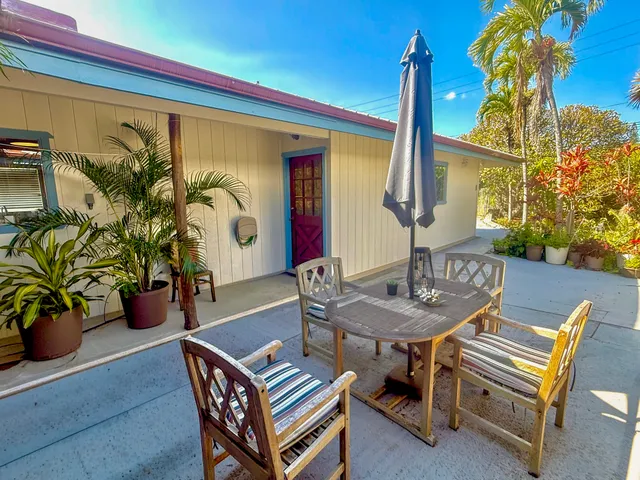 a backyard of a house with barbeque oven table and chairs