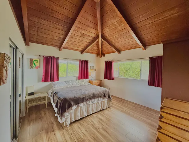 a bedroom with a bed next to a window
