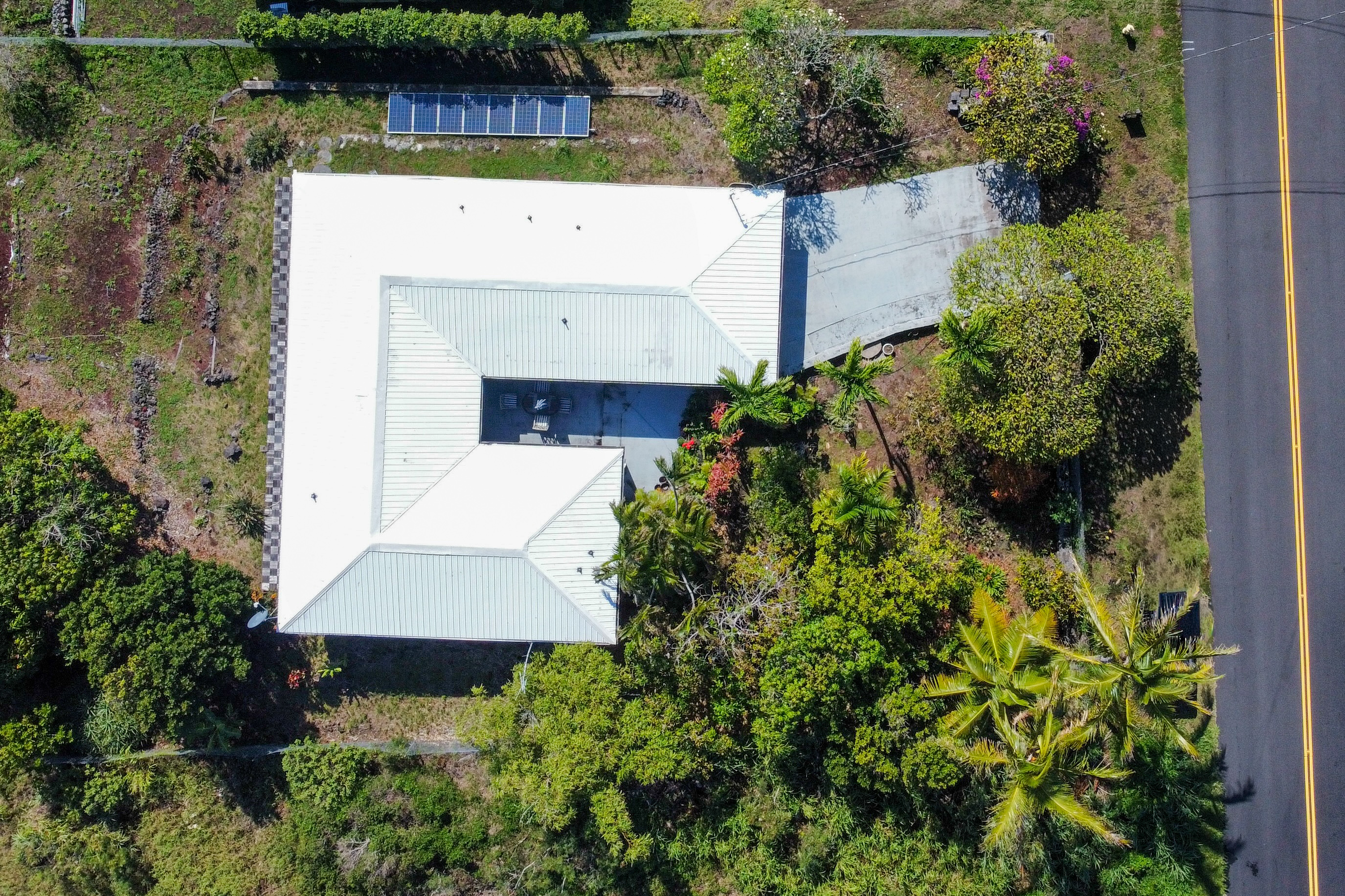 94-1726 Wakea Avenue Naalehu, HI 96772 - Photo 2 of 30 an aerial view of a house with a yard and garden