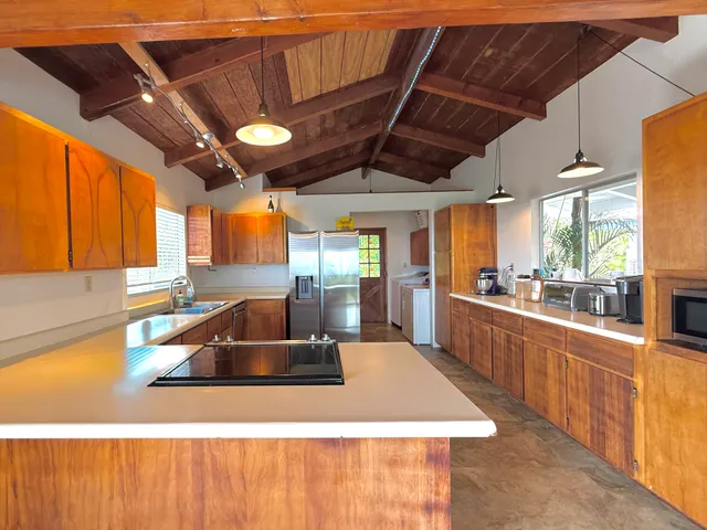 a kitchen with stainless steel appliances granite countertop a sink a counter space and a window